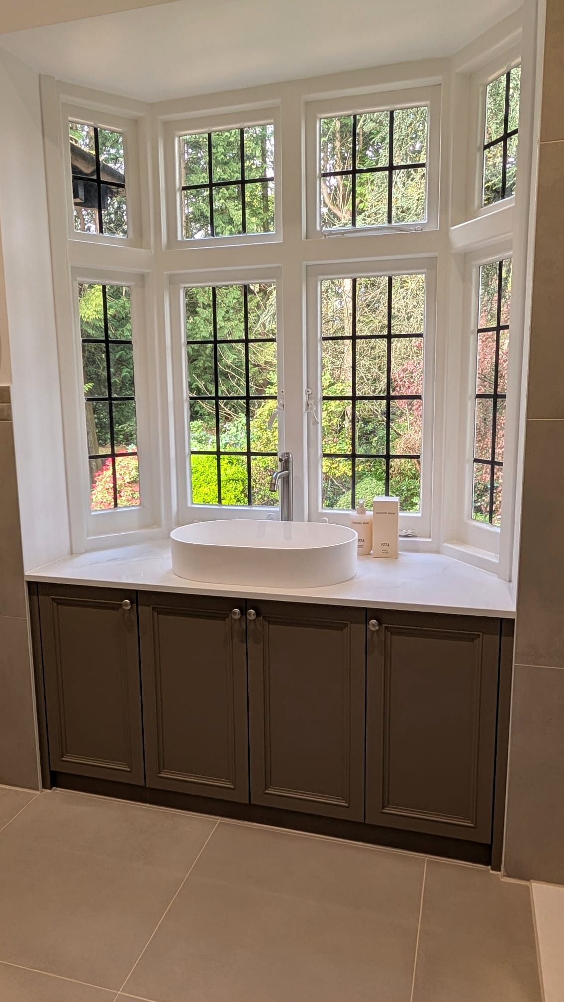 IMG-20260415-WA0001 Bespoke fitted bay window vanity unit in Dorset, built in moisture-resistant MDF with shaker doors, inset basin and clean painted finish beneath traditional sash windows.