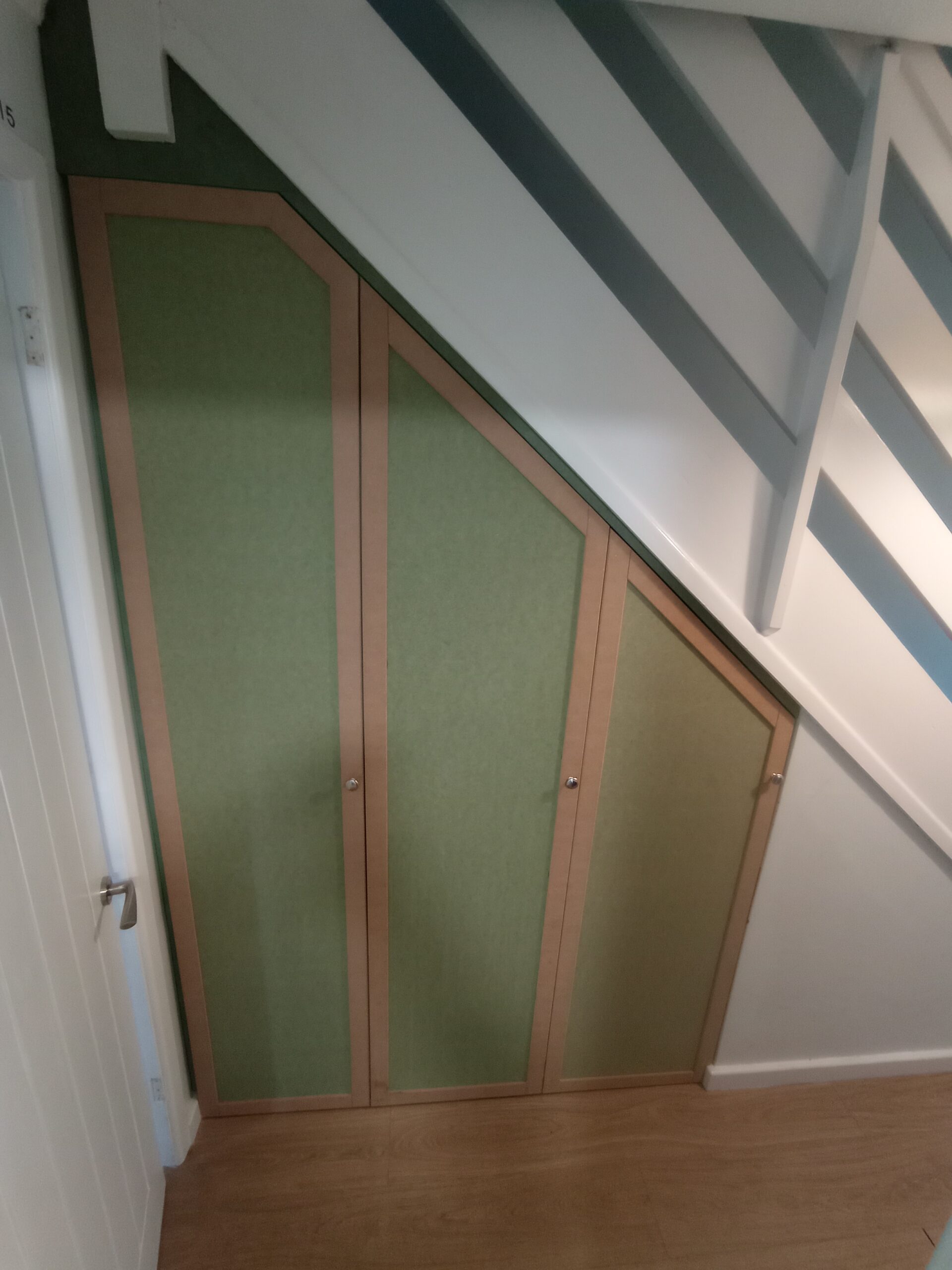 IMG_20240708_173528 (2) Bespoke under-stairs storage with fitted cupboard doors following the stair profile.