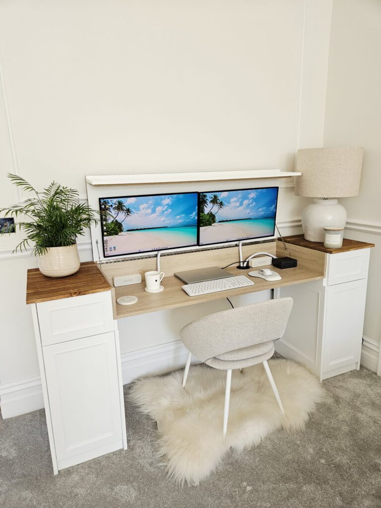 Custom fitted desk with shaker cabinets and fold-down workspace with dual monitors in home office alcove